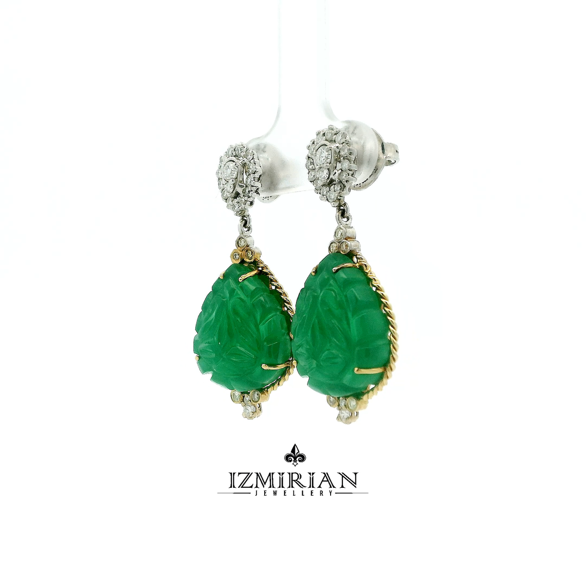 Angled view of yellow gold earrings with carved emerald drops