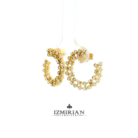 Angled view of diamond lattice hoop earrings in yellow gold