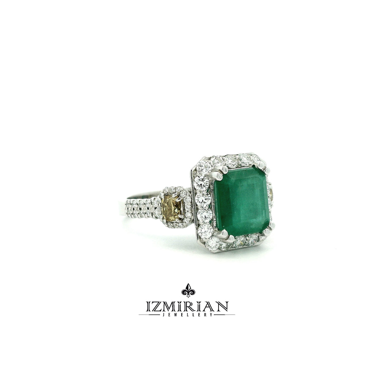 Side view of emerald ring with round diamond halo and yellow diamond accents