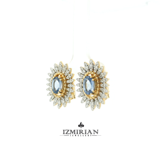 Angled side shot of two-tone sapphire earrings with layered diamond design