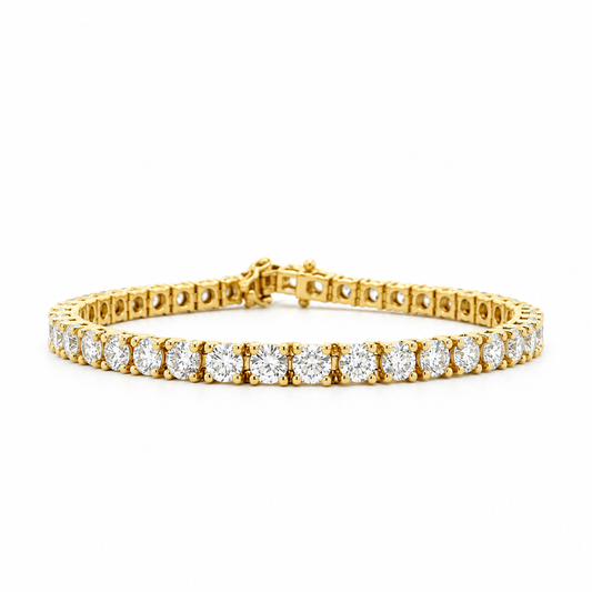 A yellow gold tennis bracelet featuring a continuous row of round-cut clear gemstones in a prong setting, displayed on a clean white background.