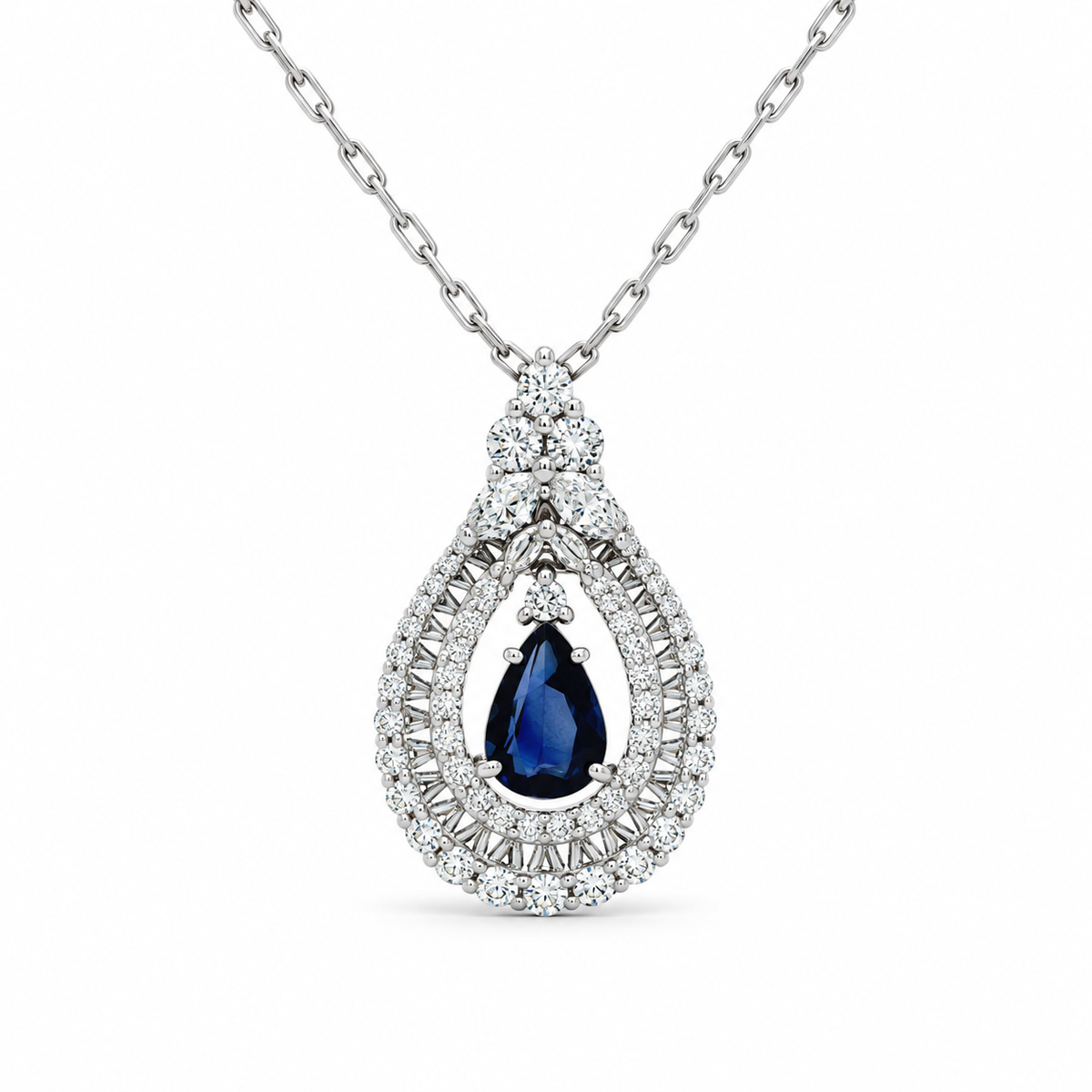 A pear-cut blue sapphire pendant necklace set in a silver-toned diamond halo and chain, shown against a plain white background.