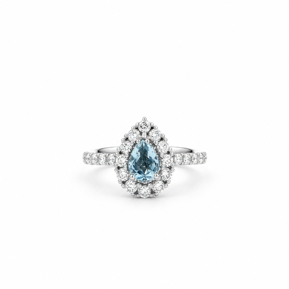 A pear-cut blue Sapphire ring with a halo of small clear stones and a diamond-like band, centered on a plain white background.