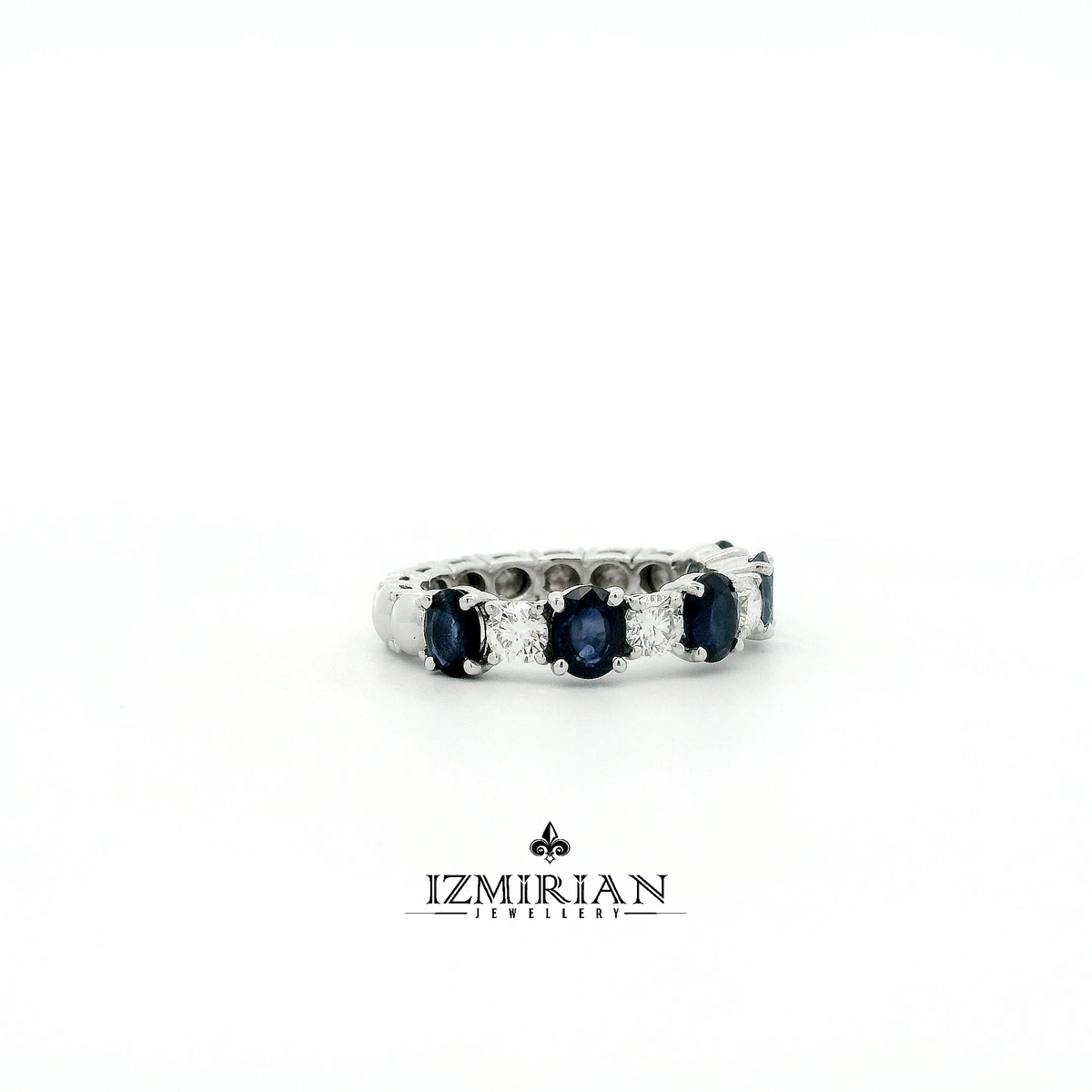 Side view of white gold sapphire and diamond eternity band showing prong setting