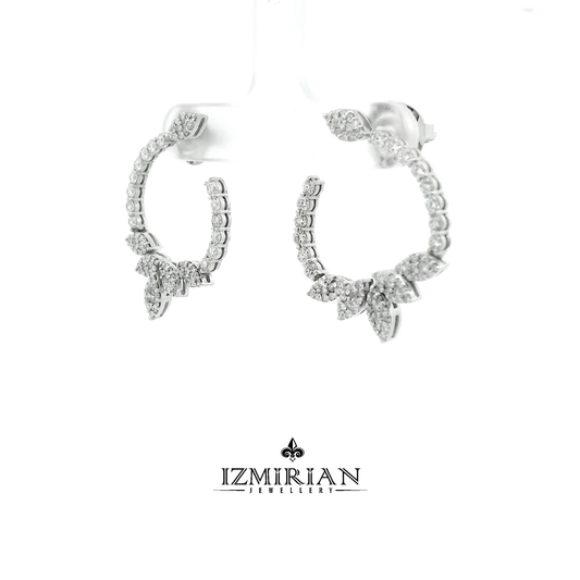 Angled view of diamond leaf hoop earrings in white gold