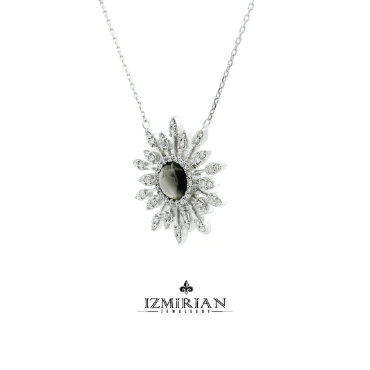 Angled view of grey cabochon gemstone necklace with diamond sunburst design
