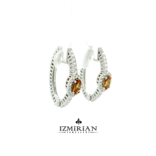 Side view of white gold earrings with orange sapphire and diamond halo