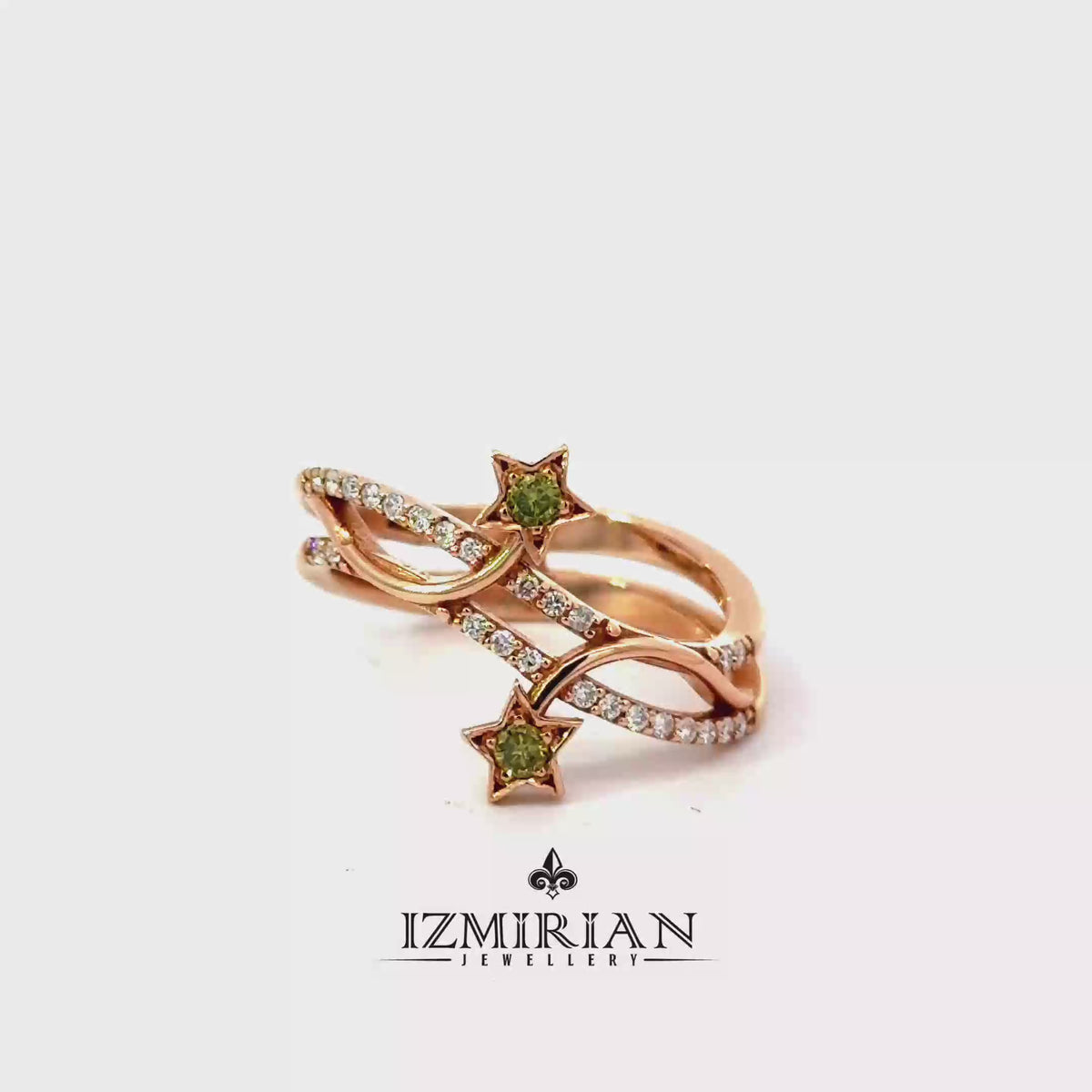 Rose gold star motif diamond ring with green gemstones shown in motion