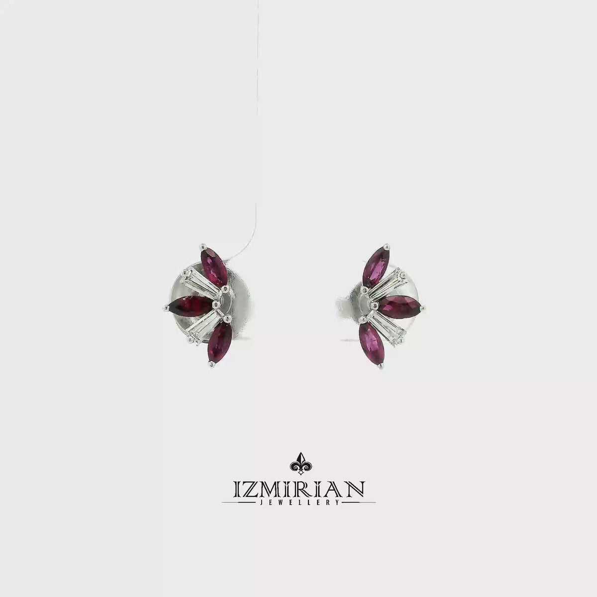 Ruby and baguette diamond stud earrings in white gold shown in motion