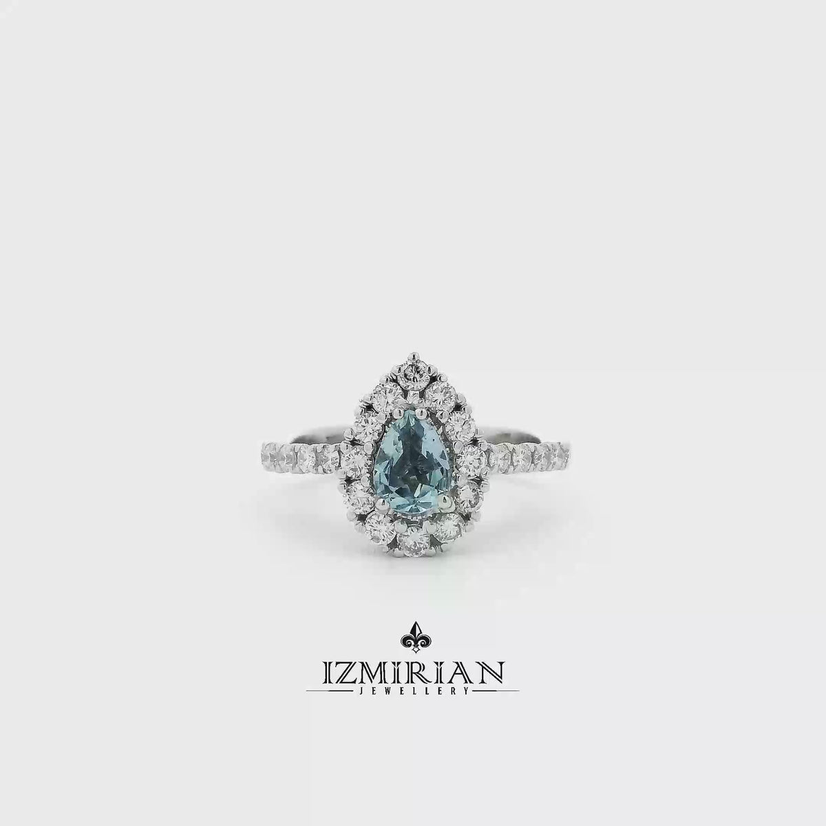 Pear-cut aquamarine halo ring in white gold shown in motion
