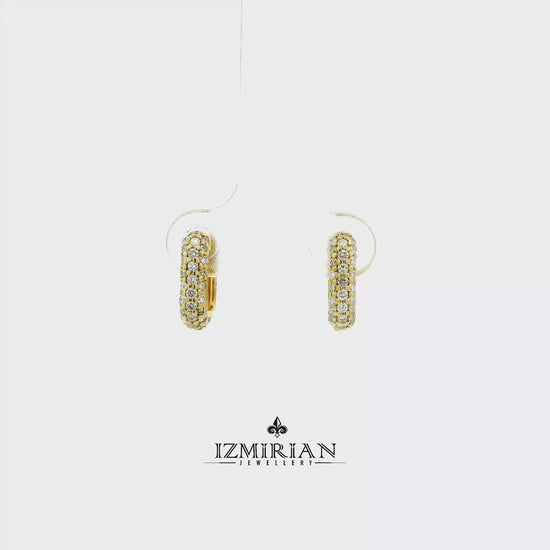 Pavé diamond huggie hoop earrings in yellow gold shown in motion