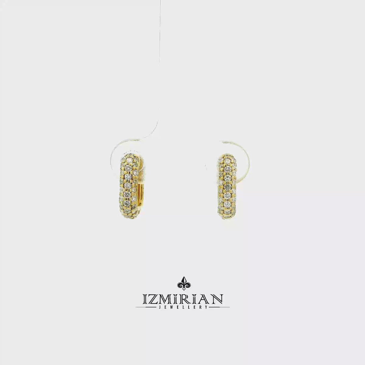 Pavé diamond huggie hoop earrings in yellow gold shown in motion