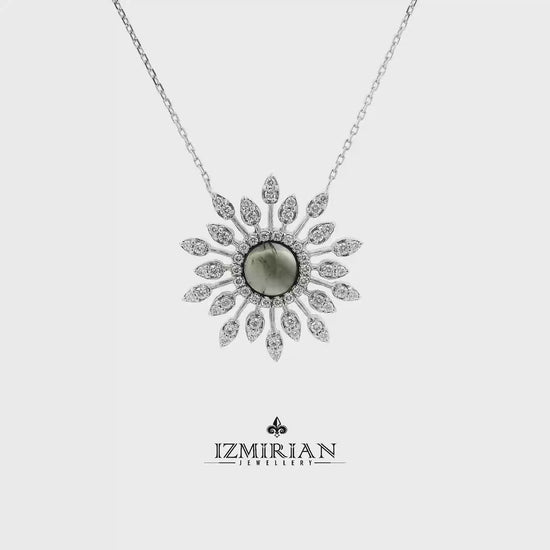 Grey gemstone and diamond sunburst necklace in white gold shown in motion