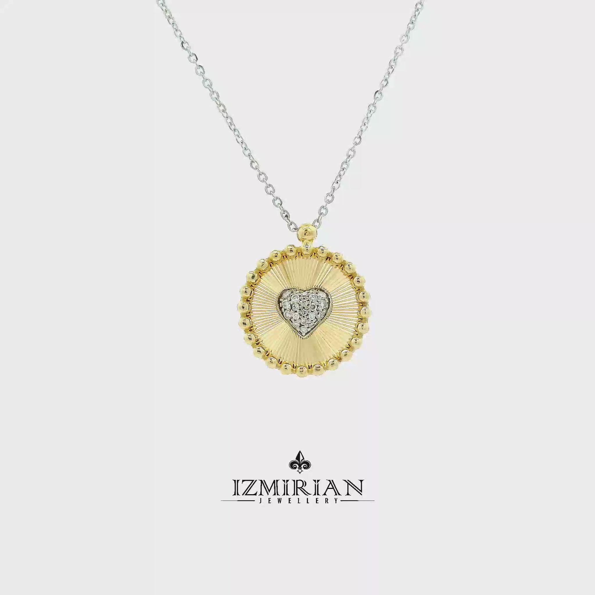Diamond heart medallion pendant in yellow and white gold shown in motion