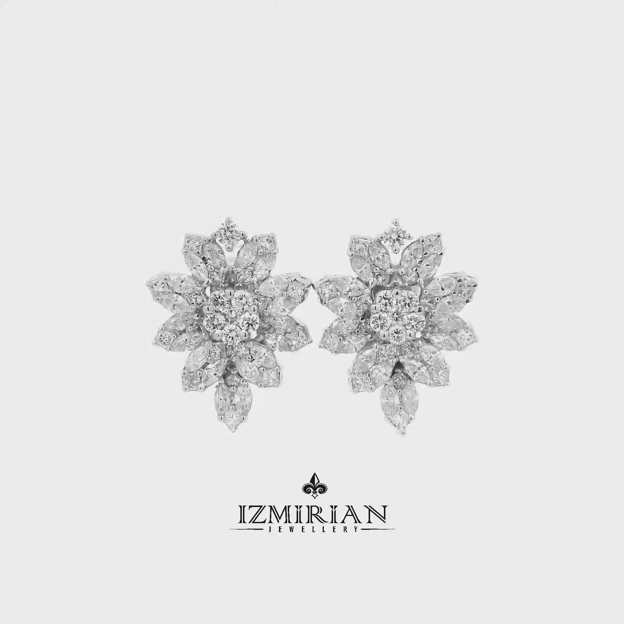 Diamond flower cluster stud earrings in white gold shown in motion
