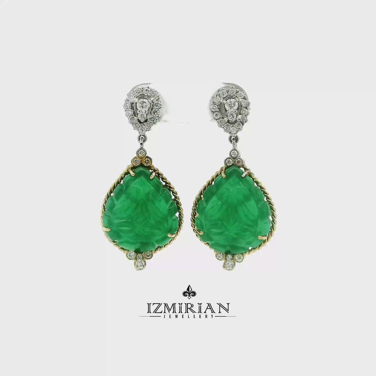 Carved emerald drop earrings in yellow and white gold shown in motion