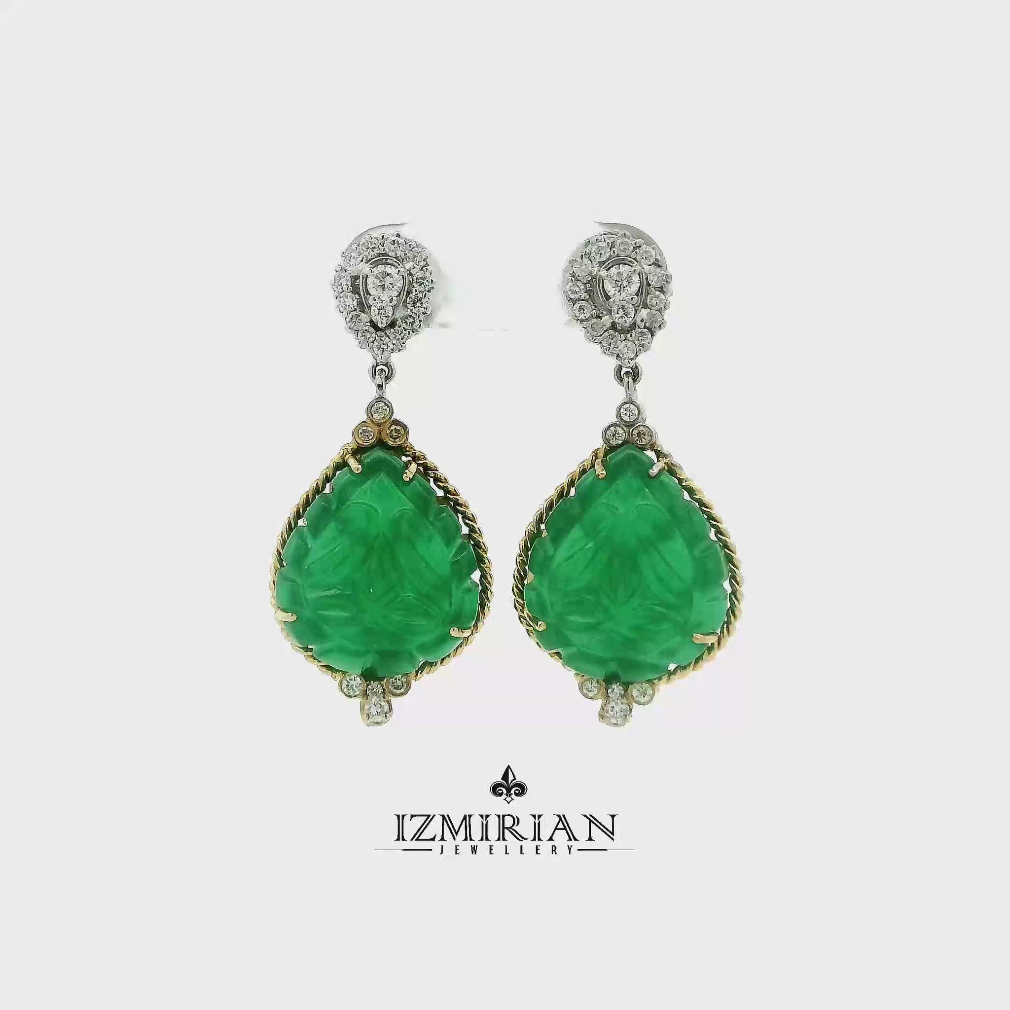 Carved emerald drop earrings in yellow and white gold shown in motion
