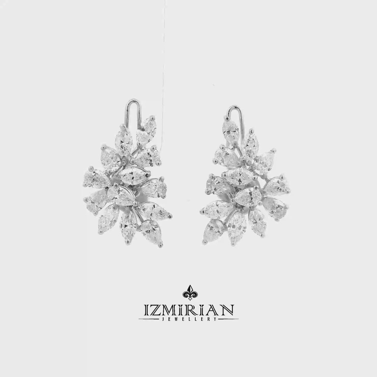 Diamond cluster drop earrings in white gold shown in motion
