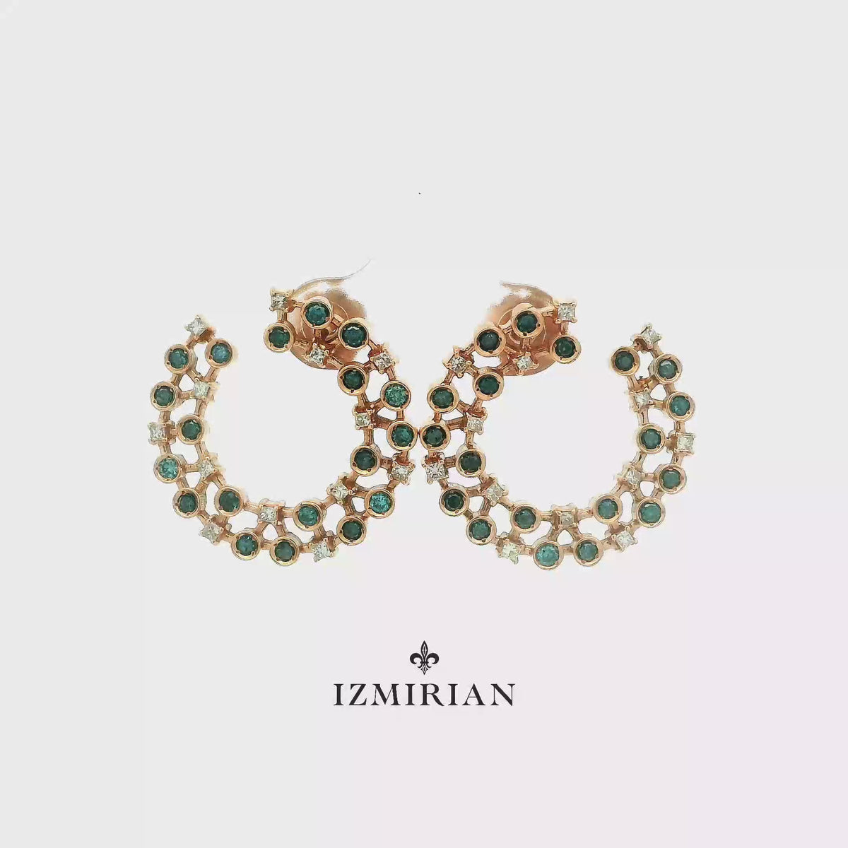 Emerald and diamond open hoop earrings in rose gold shown in motion