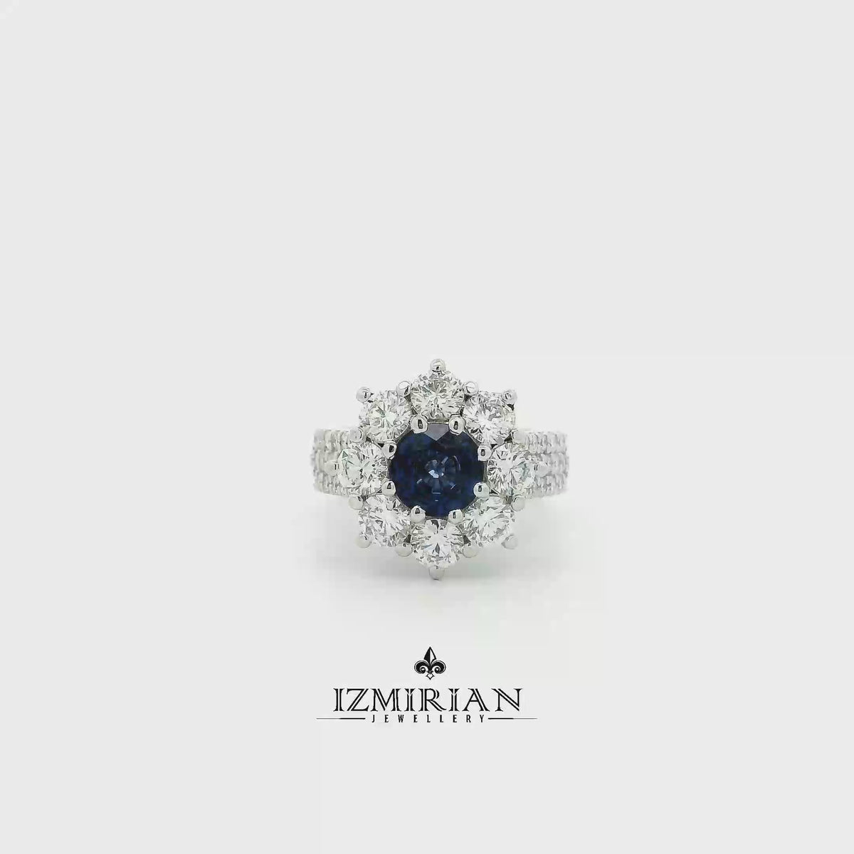 Blue sapphire and diamond cluster ring in white gold shown in motion