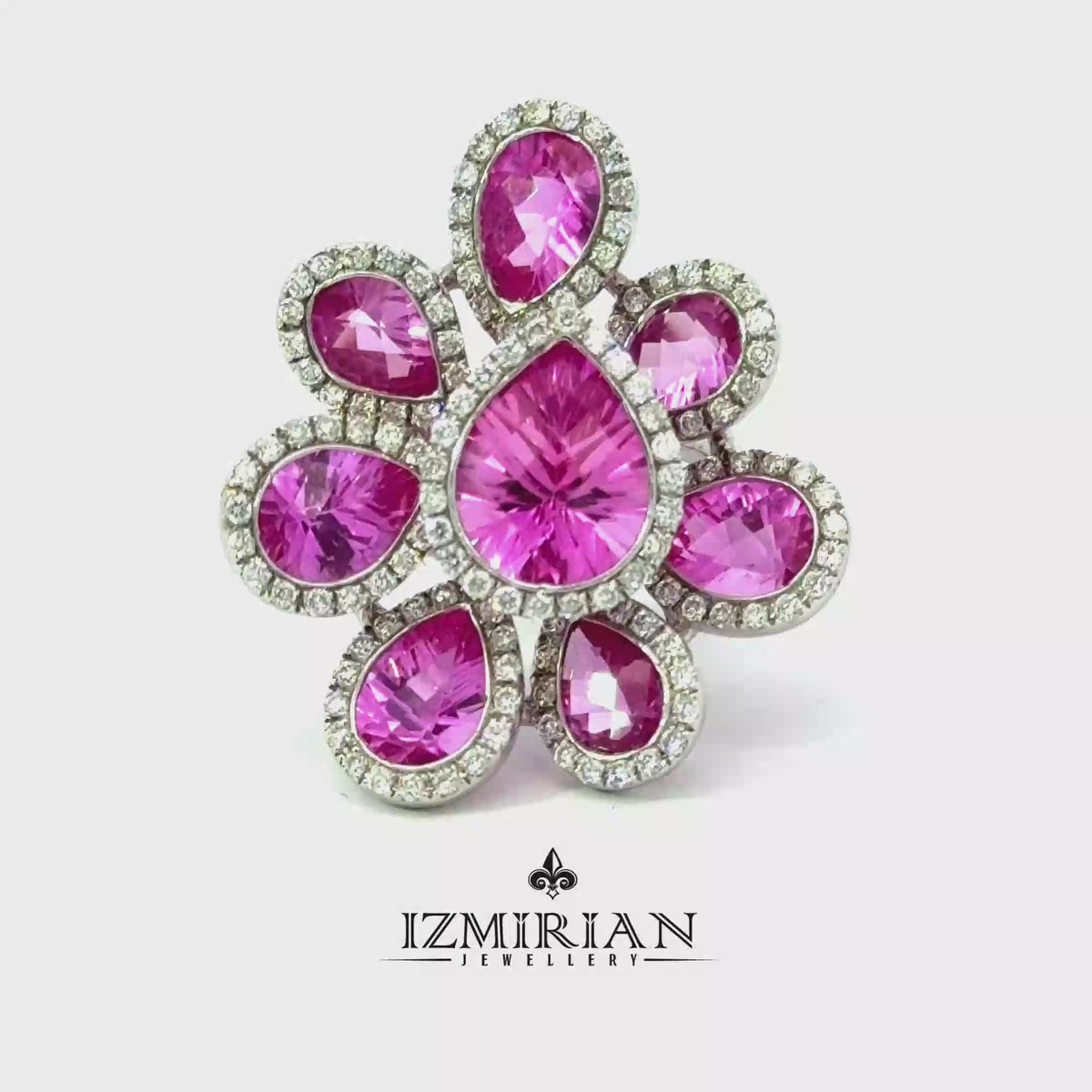 Pink sapphire and diamond flower ring in white gold shown in motion