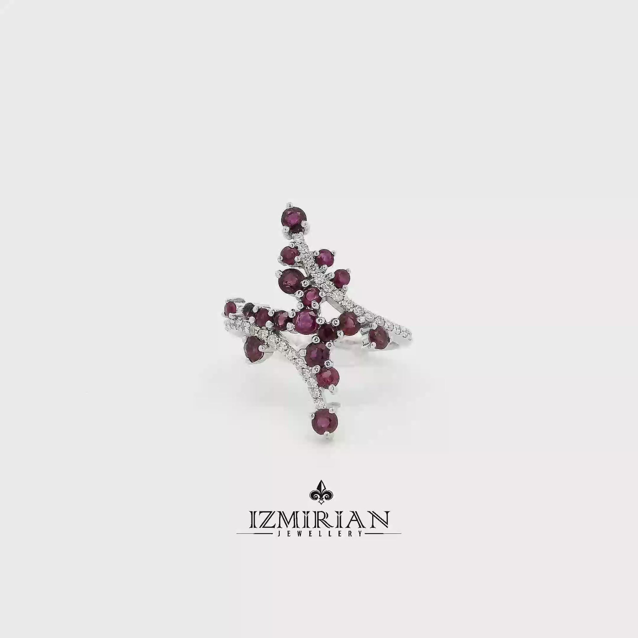 Ruby and diamond cross cluster ring in white gold shown in motion
