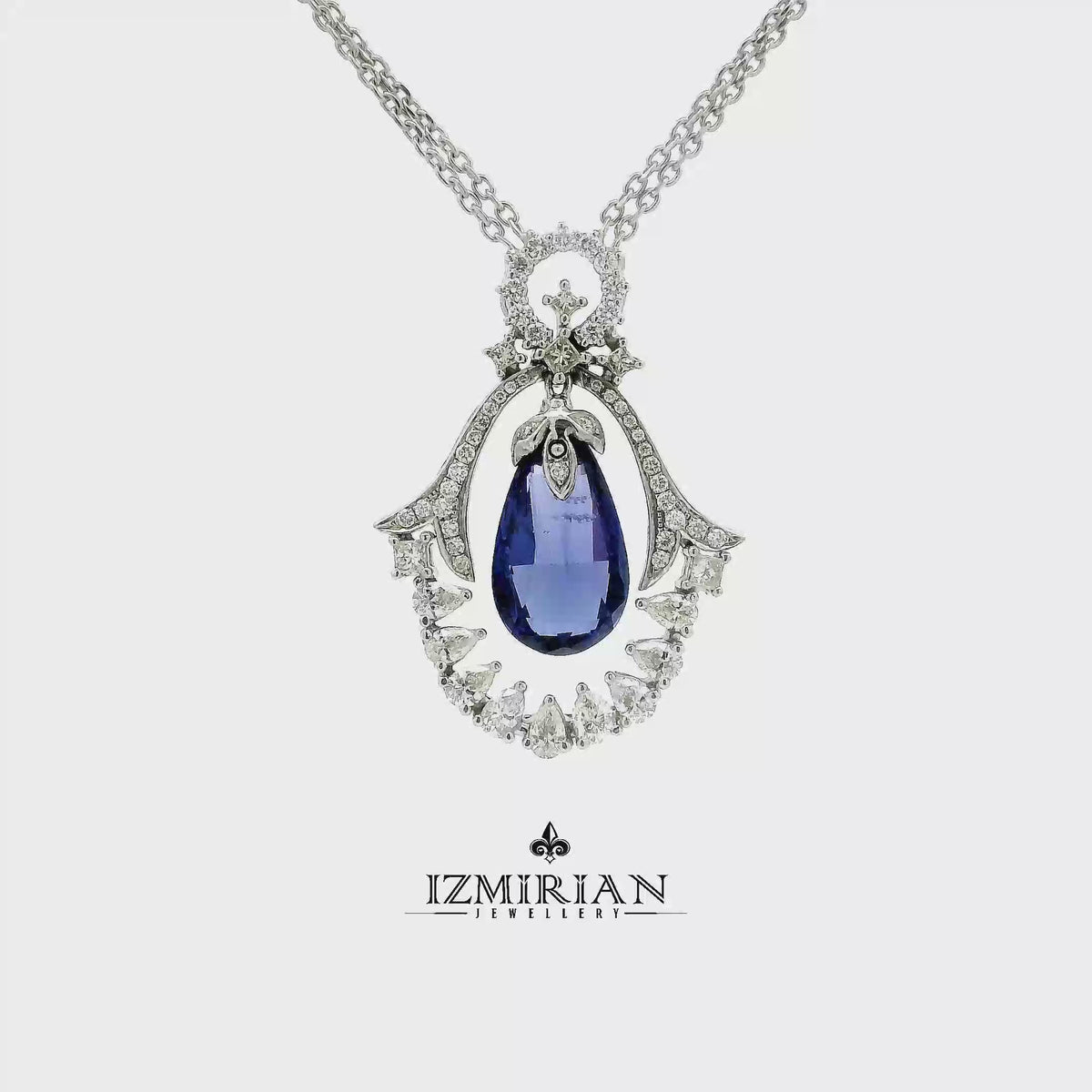 Blue sapphire diamond halo pendant in white gold shown in motion
