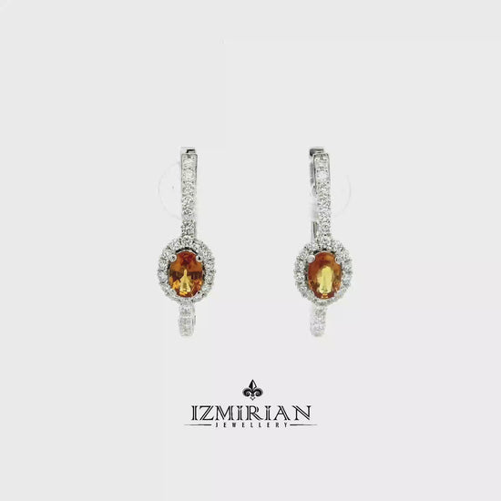 Orange sapphire and diamond drop earrings in white gold shown in motion