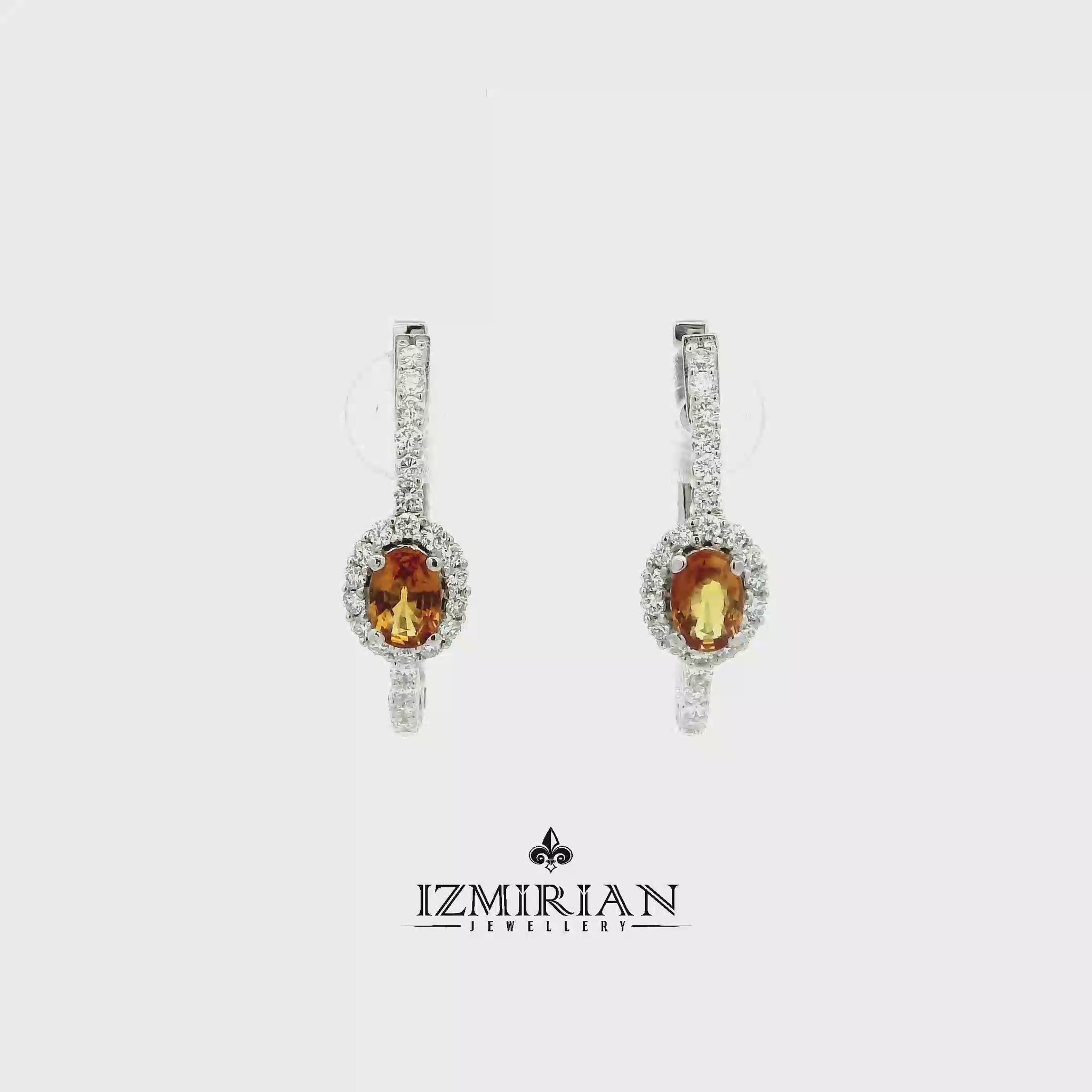 Orange sapphire and diamond drop earrings in white gold shown in motion