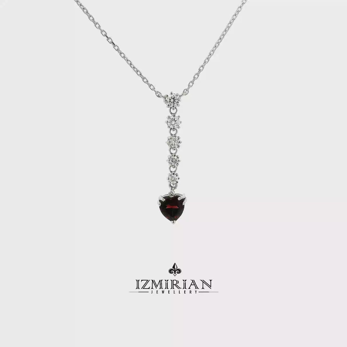 Heart garnet and diamond drop necklace in white gold shown in motion