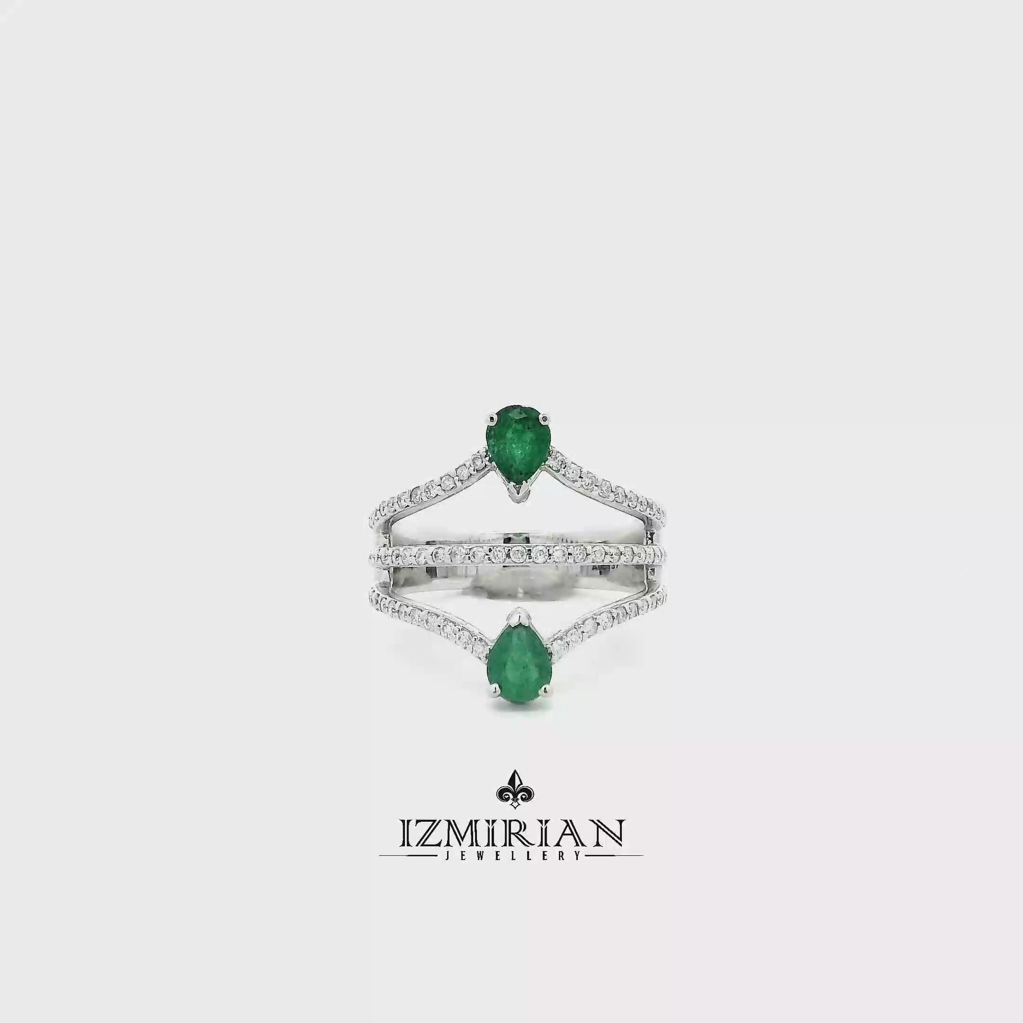 White gold ring with pear-shaped emeralds and diamond bands shown in motion