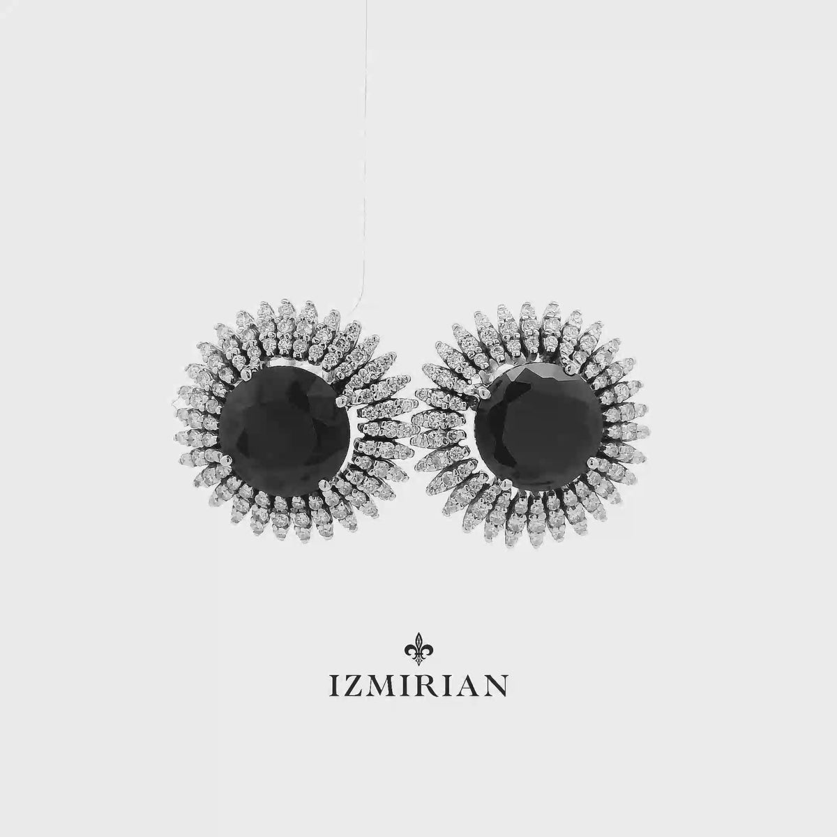 Black diamond sunburst stud earrings in white gold shown in motion