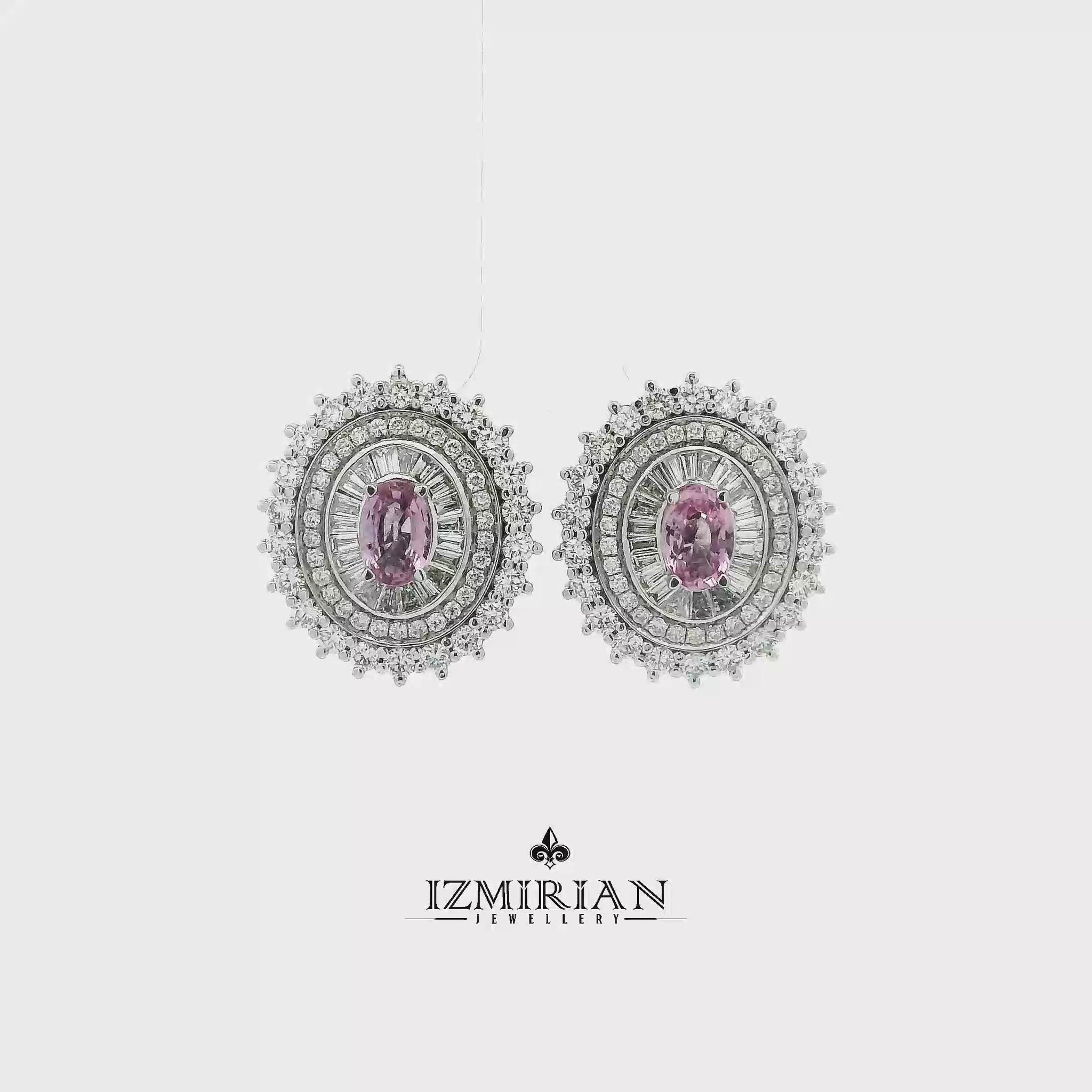Pink sapphire and diamond halo earrings in white gold shown in motion