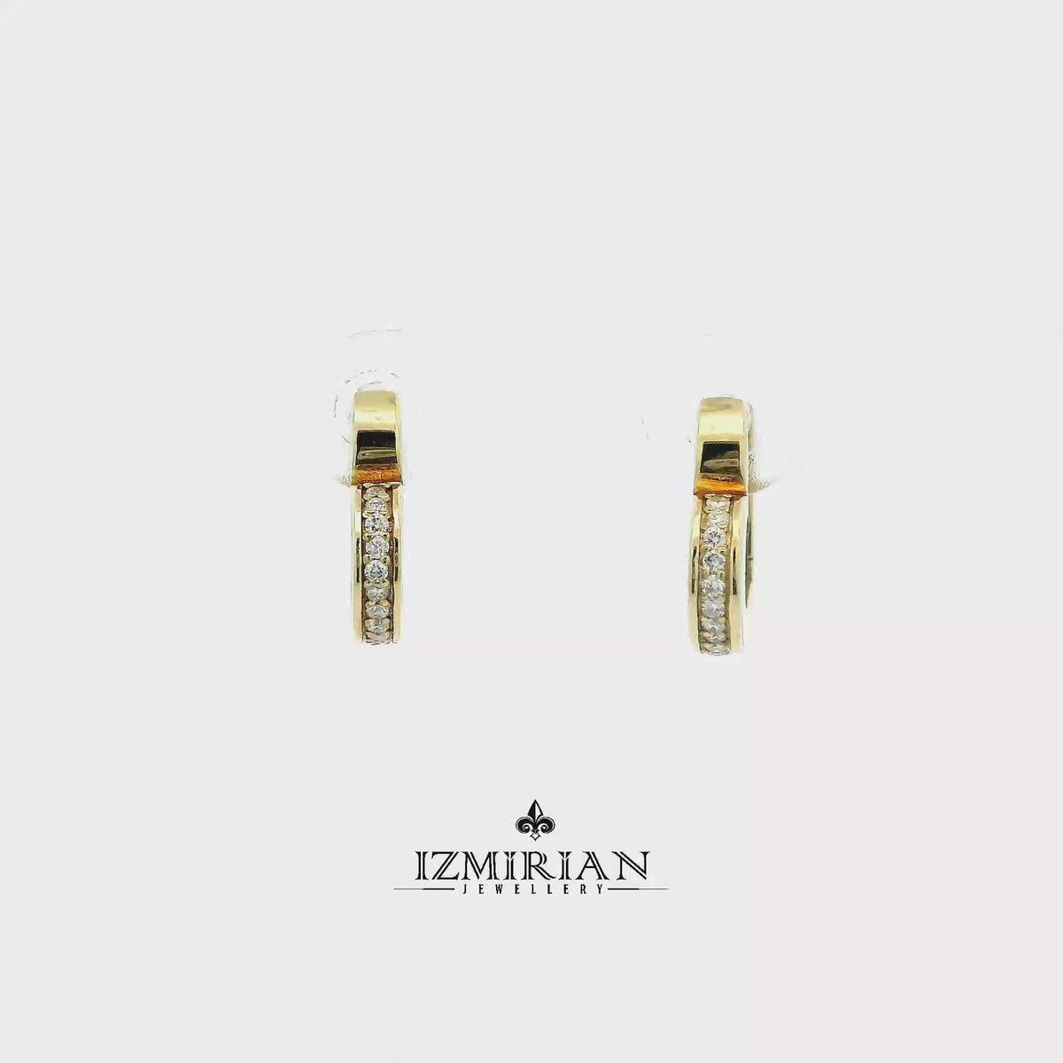 White enamel diamond heart hoop earrings in yellow gold shown in motion