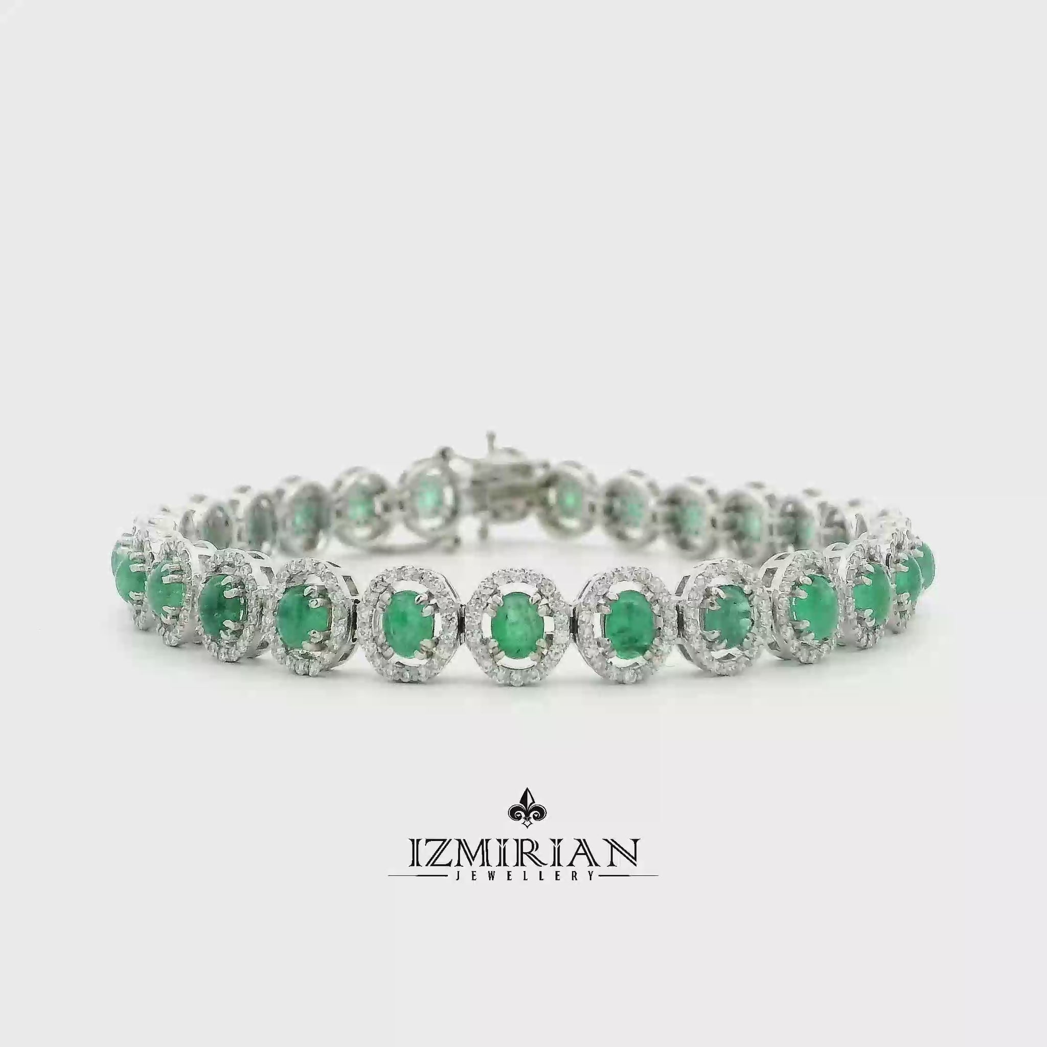 Emerald and diamond halo tennis bracelet in white gold shown in motion