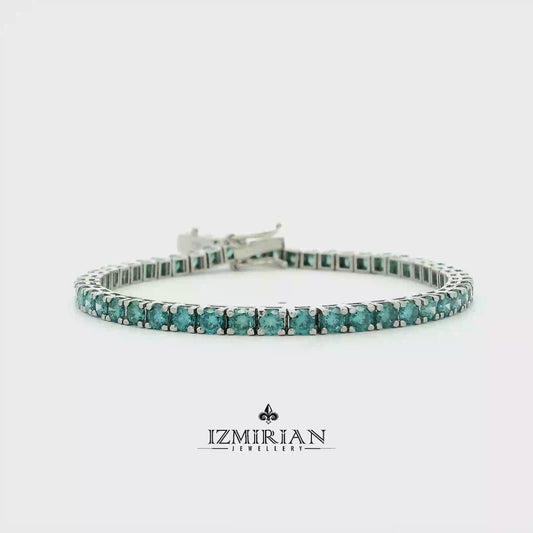 Blue diamond tennis bracelet in white gold shown in motion