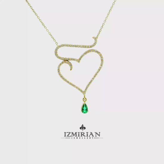 Emerald heart diamond pendant necklace in yellow gold shown in motion