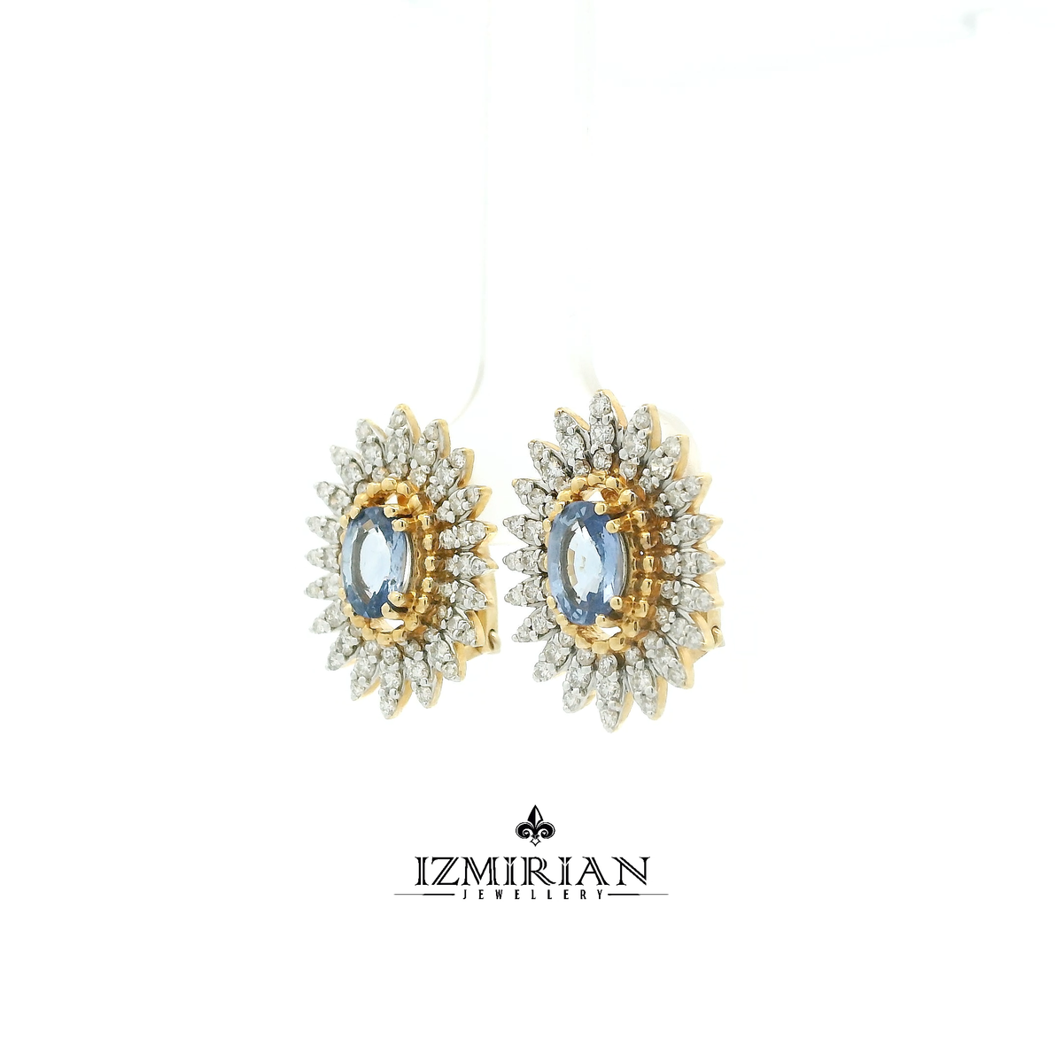 Angled side shot of two-tone sapphire earrings with layered diamond design